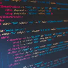 Fragment kodu SVG z definicjami gradientów i filtrów. Widać tagi `<linearGradient>`, `<filter>`, `<feGaussianBlur>`, a także atrybuty takie jak `stop-color` i `width`. To jakby twarda spacja w kodzie, która porządkuje strukturę.