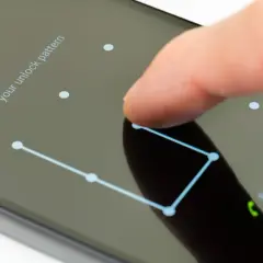 Palec rysuje wzór na ekranie telefonu, pokazując, jak odblokować telefon.