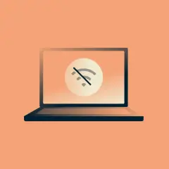 Laptop z symbolem przekreślonego Wi-Fi. Brak internetu uniemożliwia pracę.