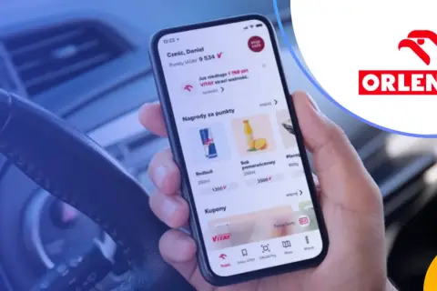 Dłoń trzyma smartfon z aplikacją ORLEN Pay, pokazującą punkty VITAY i nagrody.