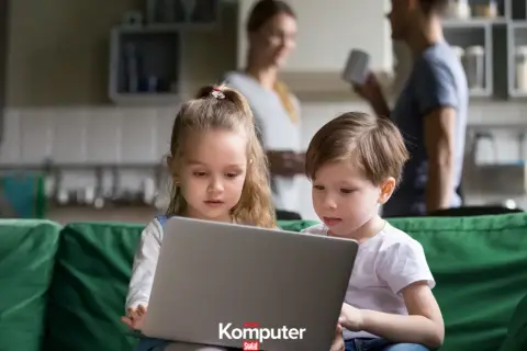 Dzieci korzystają z laptopa, rodzice czuwają. Kontrola rodzicielska na komputerze zapewnia bezpieczeństwo.