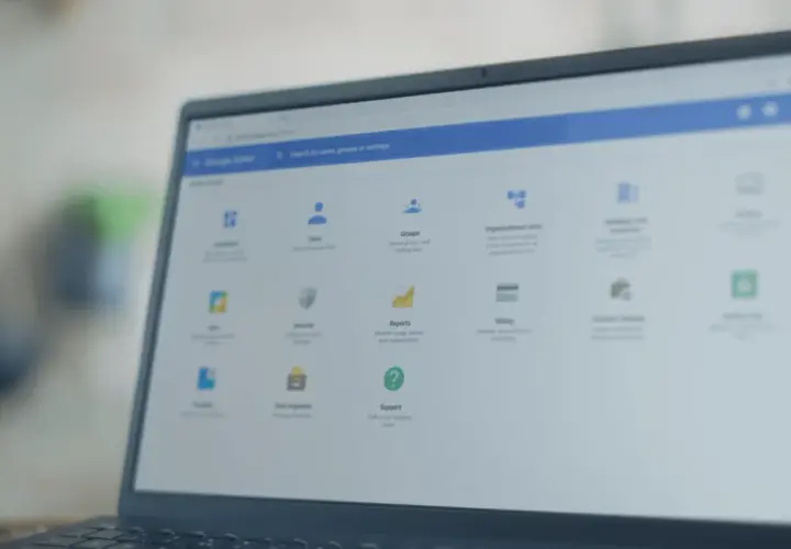 Panel administracyjny Google na laptopie z systemem **Chrome OS**. Widoczne opcje: Użytkownicy, Grupy, Raporty, Wsparcie.