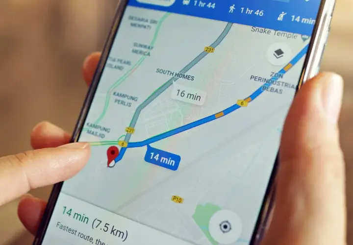 Palec dotyka ekranu telefonu z mapą, pokazując trasę i czas dojazdu. Dowiedz się, jak wysłać pinezkę z lokalizacją.