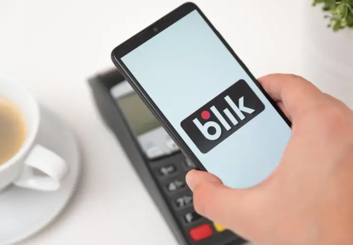 Zbliżeniowa płatność telefonem z logo Blik. Kawa czeka, a transakcja przebiega błyskawicznie.