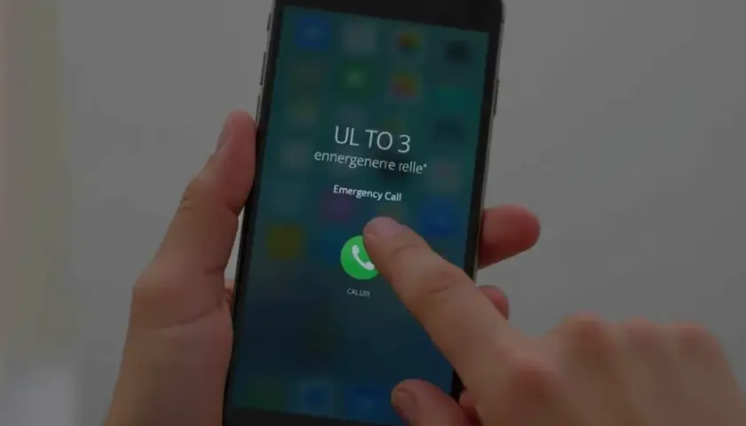 Palec dotyka ikony połączenia alarmowego na ekranie telefonu, pokazując, jak odblokować telefon przez połączenie alarmowe.