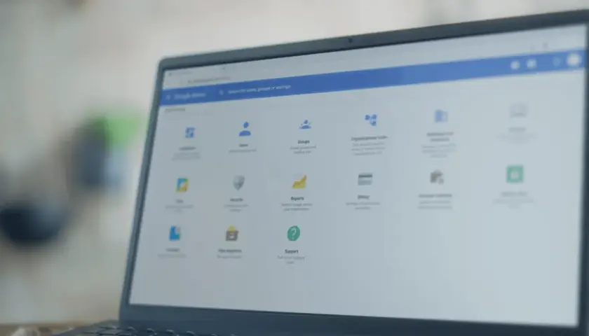 Panel administracyjny Google na laptopie z systemem **Chrome OS**. Widoczne opcje: Użytkownicy, Grupy, Raporty, Wsparcie.