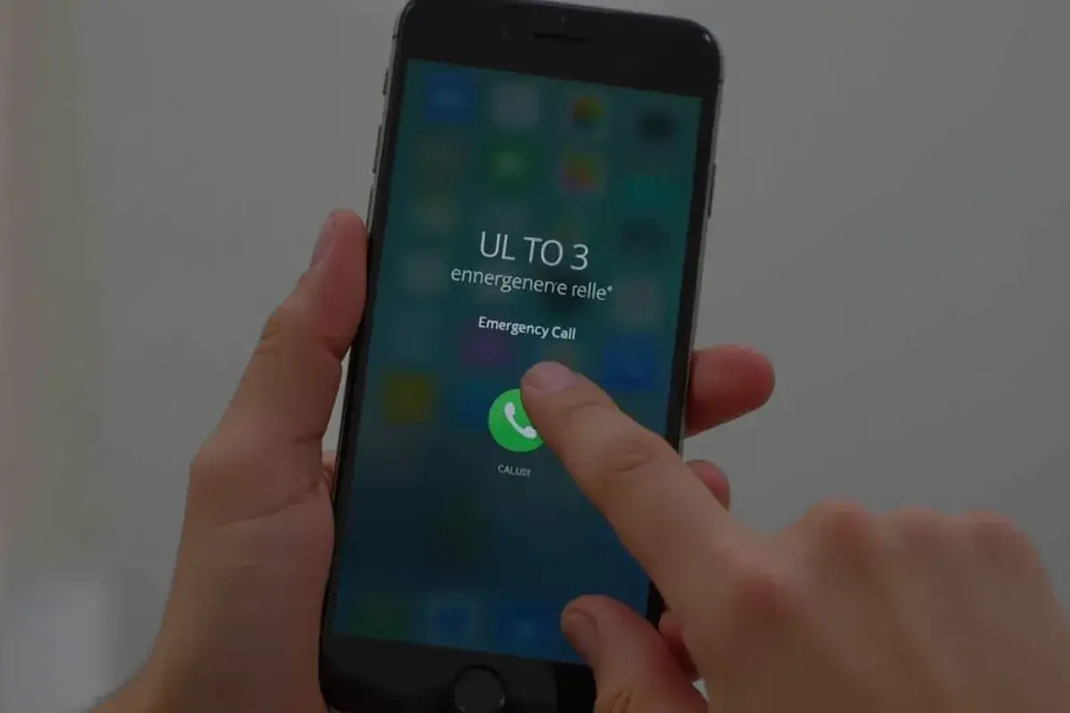 Palec dotyka ikony połączenia alarmowego na ekranie telefonu, pokazując, jak odblokować telefon przez połączenie alarmowe.