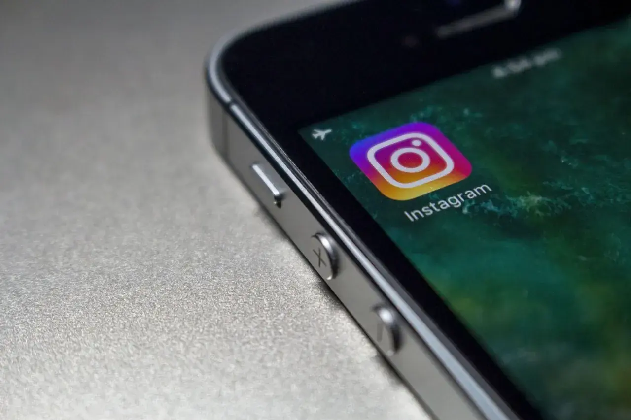 Zbliżenie na ekran telefonu z ikoną Instagrama. Czy widac screeny relacji na IG?
