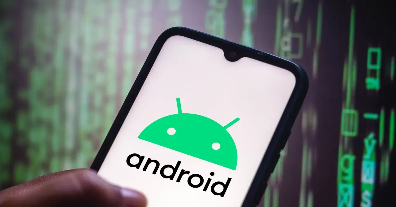 Dłoń trzyma smartfon z logo Android 10. Tło to zielony, rozmyty kod.