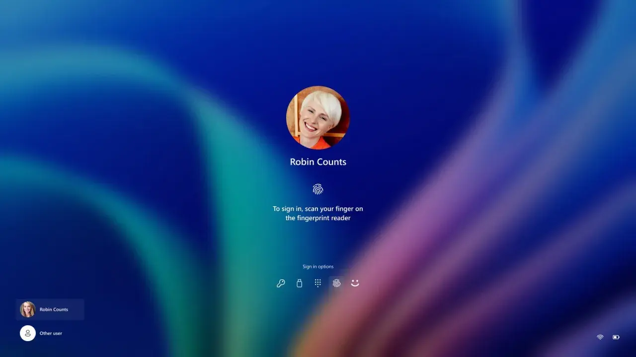 Ekran logowania Windows Hello z uśmiechniętą Robin Counts. Zeskanuj palec, by się zalogować.