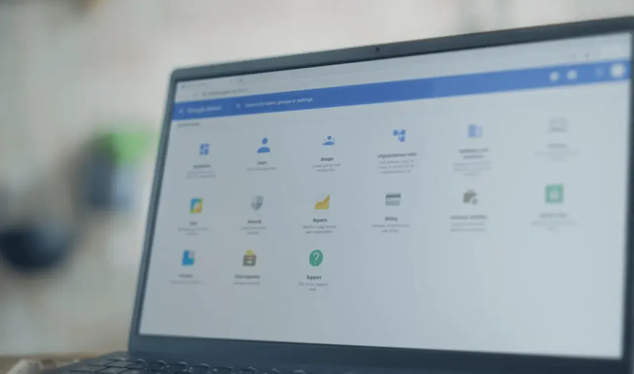 Panel administracyjny Google na laptopie z systemem **Chrome OS**. Widoczne opcje: Użytkownicy, Grupy, Raporty, Wsparcie.