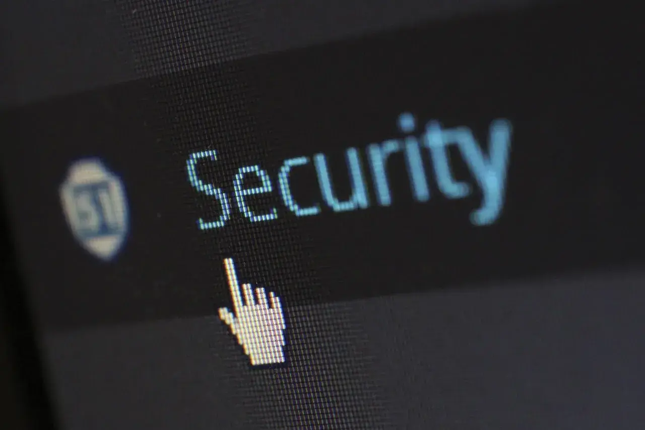 Kursor myszy nad napisem "Security", symbolizuje potrzebę zarządzania ustawieniami, np. jak wyłączyć Windows Defender.