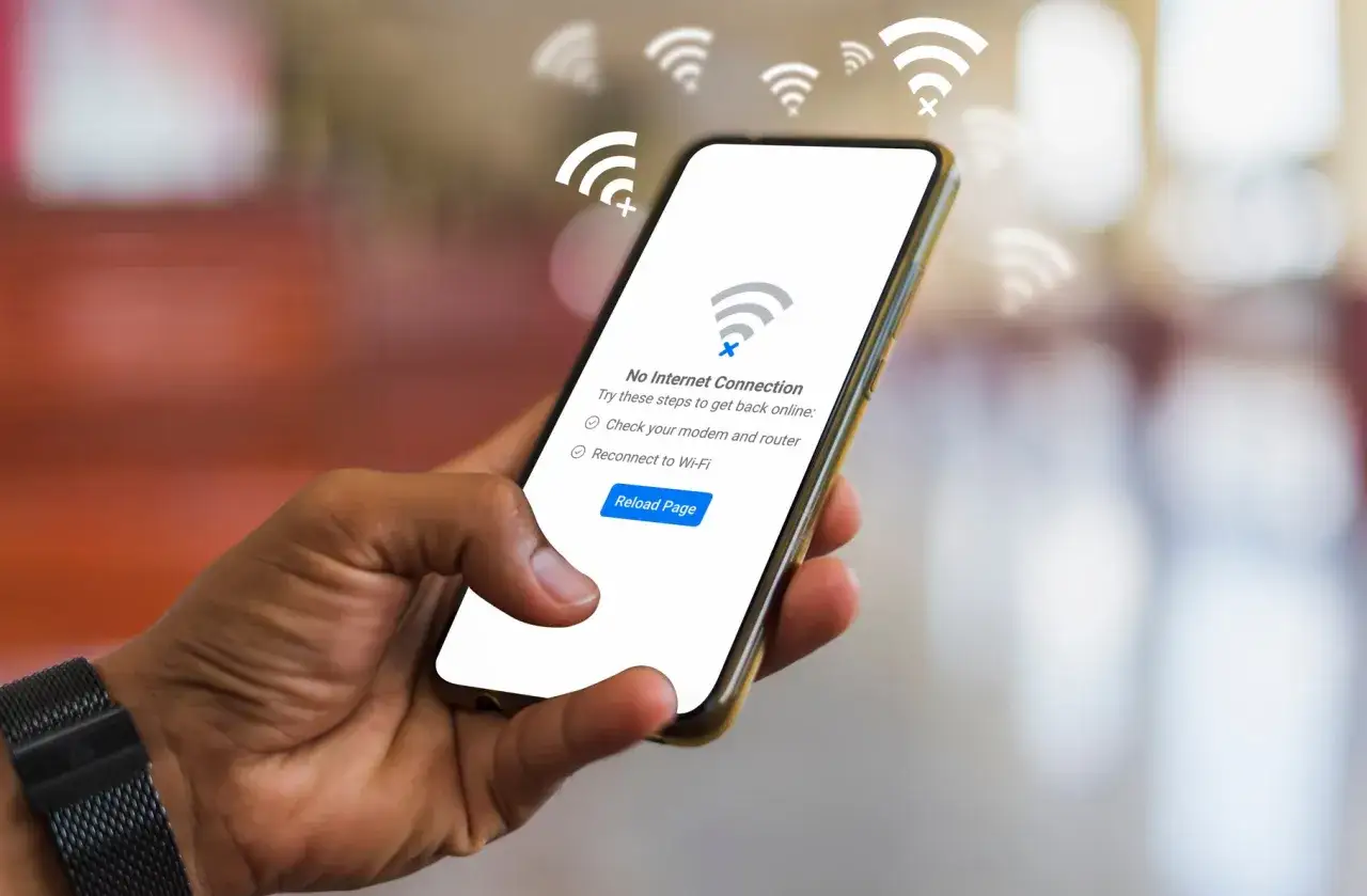 Dłoń trzyma smartfon z komunikatem 