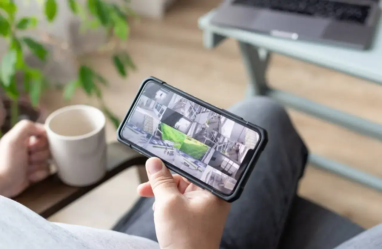 Na ekranie telefonu widoczny jest podgląd z kamer, który pozwala na podsłuch na żywo różnych pomieszczeń i otoczenia.