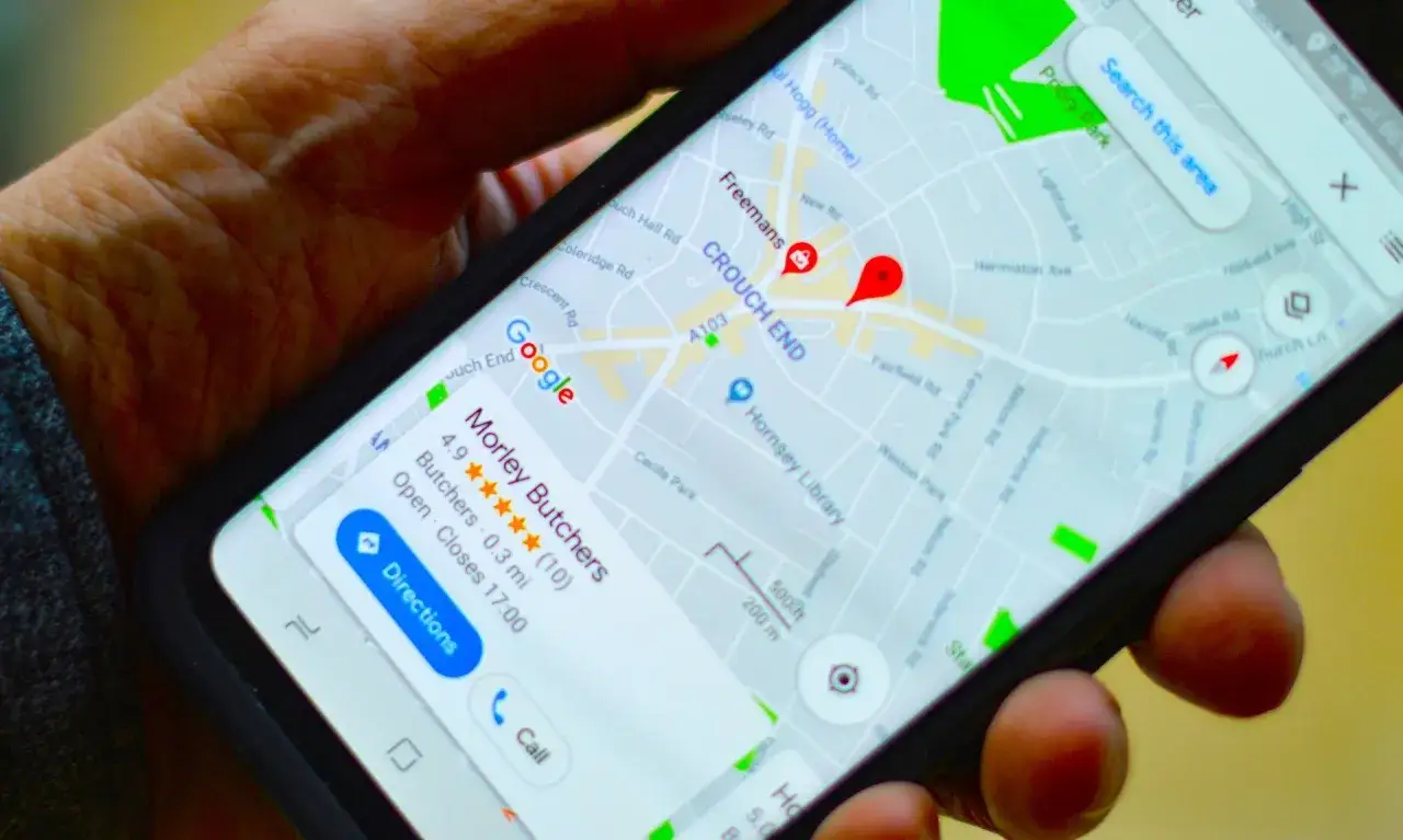 Na ekranie telefonu widoczna jest mapa Google z zaznaczoną pinezką Google w dzielnicy Crouch End. Obok wyświetla się informacja o sklepie
