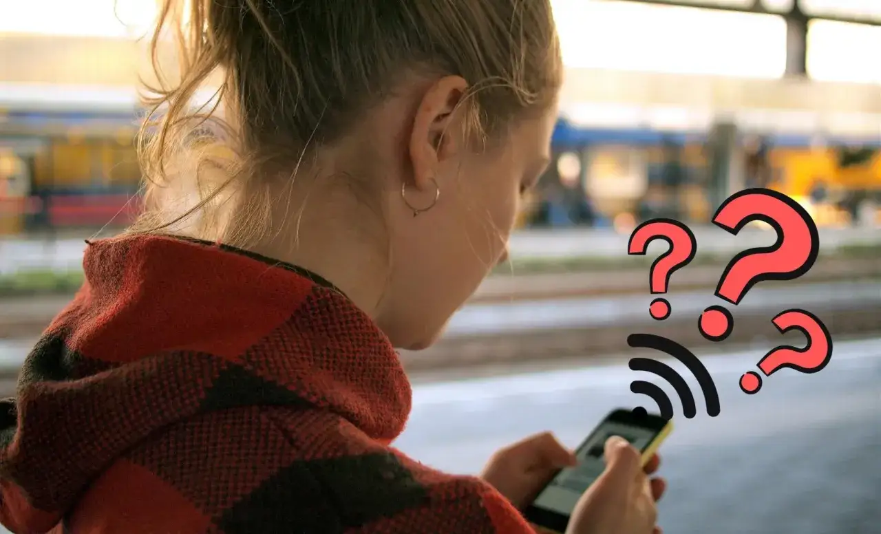 Dziewczyna z telefonem, na którym wyświetla się ikona Wi-Fi i znaki zapytania. Czyżby numer prywatny dzwonił?