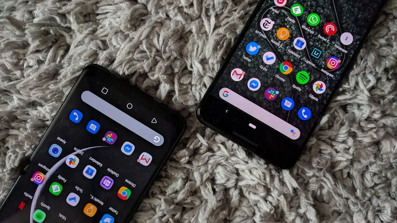 Dwa smartfony z systemem android 10 na szarym, puszystym tle. Widoczne ikony aplikacji, m.in. Chrome, Spotify, Instagram.